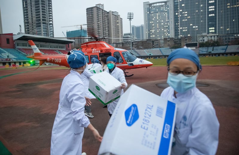epa08184452 Medical staff of Concorde hospital transfer medical supplies from a helicopter in Wuhan, Hubei Province, China, 01 February 2020. Hospitals in Wuhan and other parts of China are facing a shortage of protective masks, clothing and medical supplies as the novel coronavirus outbreak claimed so far 259 lives and infected close to 12,000 people worldwide.  EPA/YFC CHINA OUT
