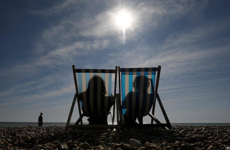 Sunbathers relax in deckchairs on the beach in Brighton, Britain, September 23, 2017. REUTERS/Toby Melville