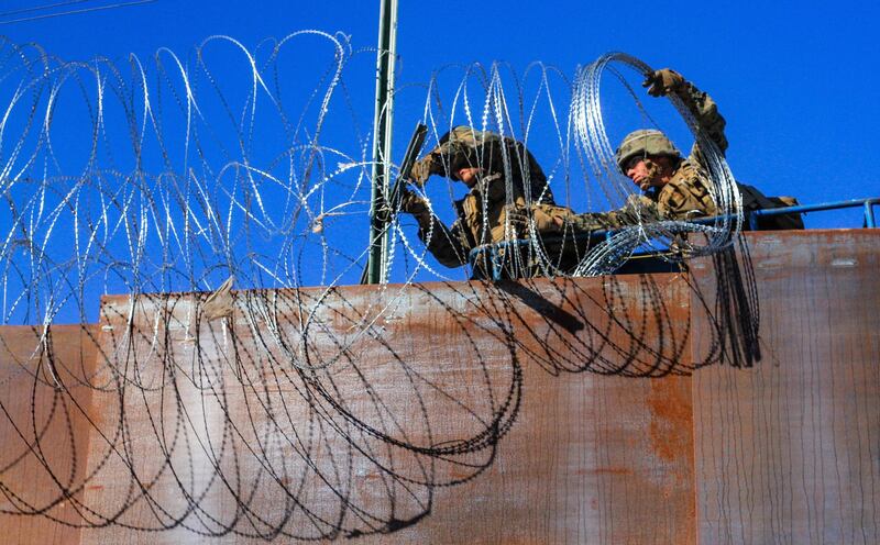 US military soldiers install barbed wire on the border with Mexico as seen from Colonia Libertad in Tijuana, Mexico. EPA