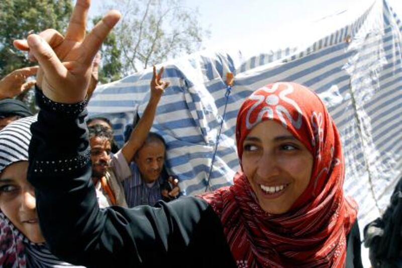 Winner of the Nobel Peace Prize Yemeni Tawakul Karman flashes a victory sign outside her tent in Tagheer square in Sanaa October 7, 2011. Karman said on Friday the award was a victory for Yemen's democracy activists and they would not give up until they had won full rights in a "democratic, modern Yemen". REUTERS/Ahmed Jadallah (YEMEN - Tags: POLITICS CIVIL UNREST SCIENCE TECHNOLOGY MEDIA TPX IMAGES OF THE DAY) *** Local Caption ***  AJS01_YEMEN-NOBEL-_1007_11.JPG