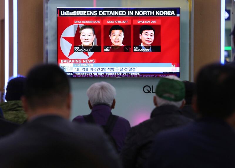 People watch a TV news report screen showing portraits of three Americans, Kim Dong Chul, left, Tony Kim and Kim Hak Song, right, detained in the North Korea at the Seoul Railway Station in Seoul, South Korea, Thursday, May 3, 2018. U.S. President Donald Trump added to speculation that North Korea may make a goodwill gesture before his planned summit with leader Kim Jong Un when he tweeted of a possible update soon on the status of three detained Americans.(AP Photo/Ahn Young-joon)