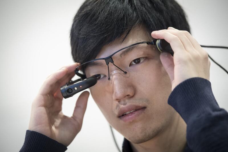 An attendee wears the Vuzix Corp. M300 augmented reality (AR) Smart Glasses during the 2018 Consumer Electronics Show (CES) in Las Vegas, Nevada, U.S., on Wednesday, Jan. 10, 2018. Electric and driverless cars will remain a big part of this year's CES, as makers of high-tech cameras, batteries, and AI software vie to climb into automakers' dashboards. Photographer: David Paul Morris/Bloomberg