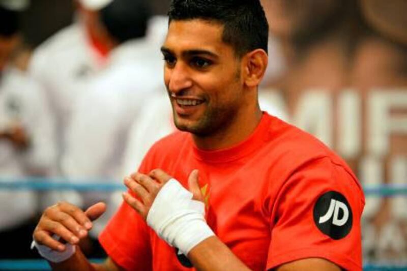 Golden Boy Productions is pursuing a multi-year deal in which Dubai would host many boxing title bouts, the first of which could be Amir Khan, above, and Devon Alexander. Paul Ellis / AFP