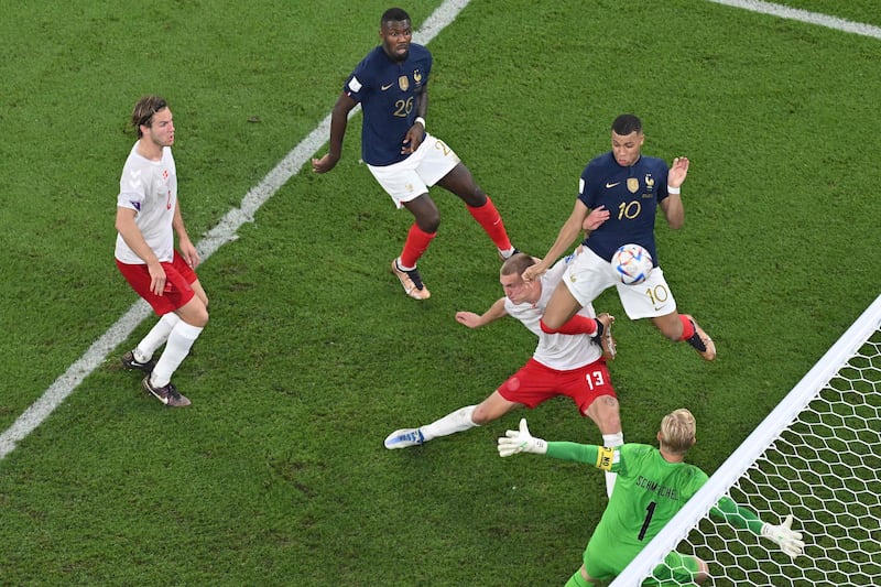 France's Kylian Mbappe bundles his team's second goal past Denmark goalkeeper Kasper Schmeichel and defender Rasmus Kristensen. AFP