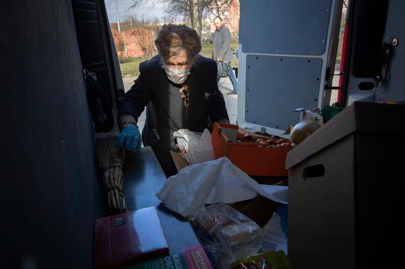 Galina Yakovleva sorts through donated goods in the back of her van, which she drives herself to make deliveries. AP Photo