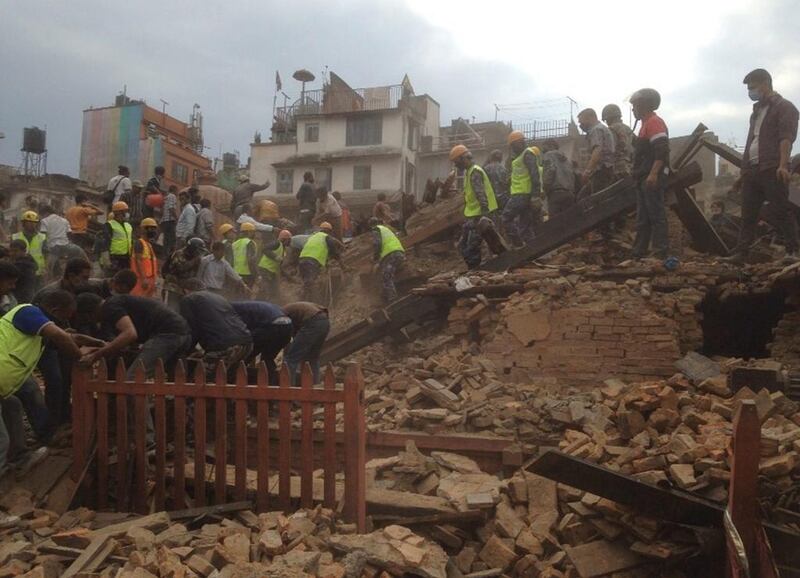Rescuers clear the debris at Durbar Sqaure after an earthquake in Kathmandu. A strong magnitude-7.9 earthquake shook Nepal's capital and the densely populated Kathmandu Valley before noon Saturday, causing extensive damage with toppled walls and collapsed buildings. Niranjan Shrestha / AP