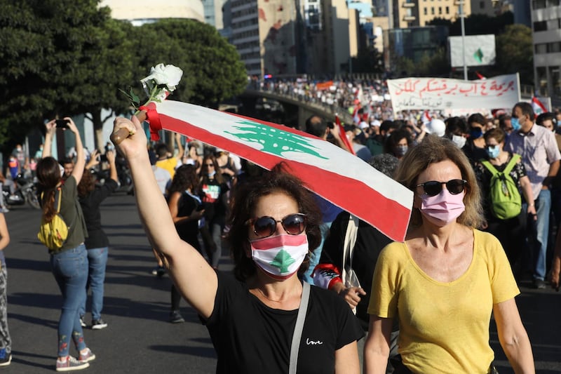 People wave Lebanese flags and chant to mark the first anniversary of anti-government protests. Getty Images