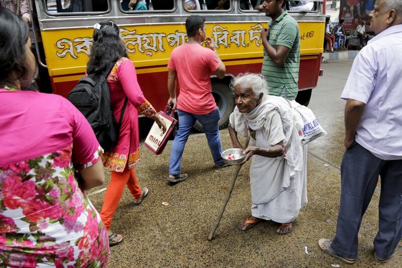 An elderly homeless woman asks for alms on a street in Kolkata.  Bikas Das / AP Photo