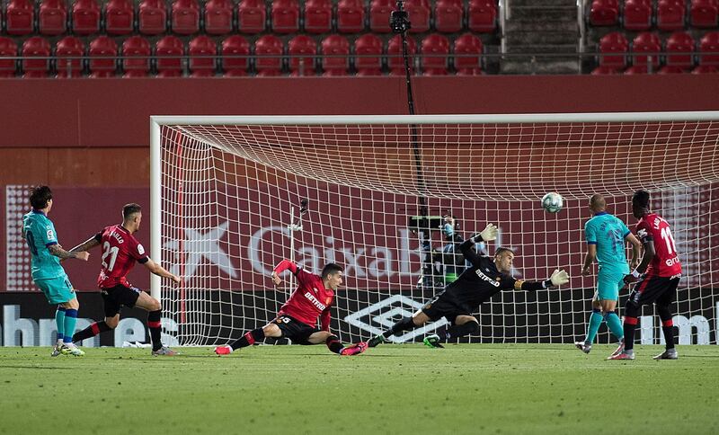 Lionel Messi (L) scores against Mallorca inside an empty Son Moix Stadium. AFP