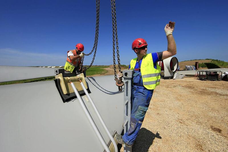 France is heavily reliant on nuclear energy, accounting for 75 per cent of its electricity. Above, employees work on a rotor blade of an E-70 wind during its installation at a wind farm in Meneslies. Benoit Tessier / Reuters