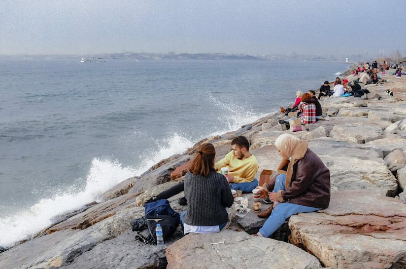 People enjoy their lunch by the seaside, at Kadikoy in Istanbul.  AFP