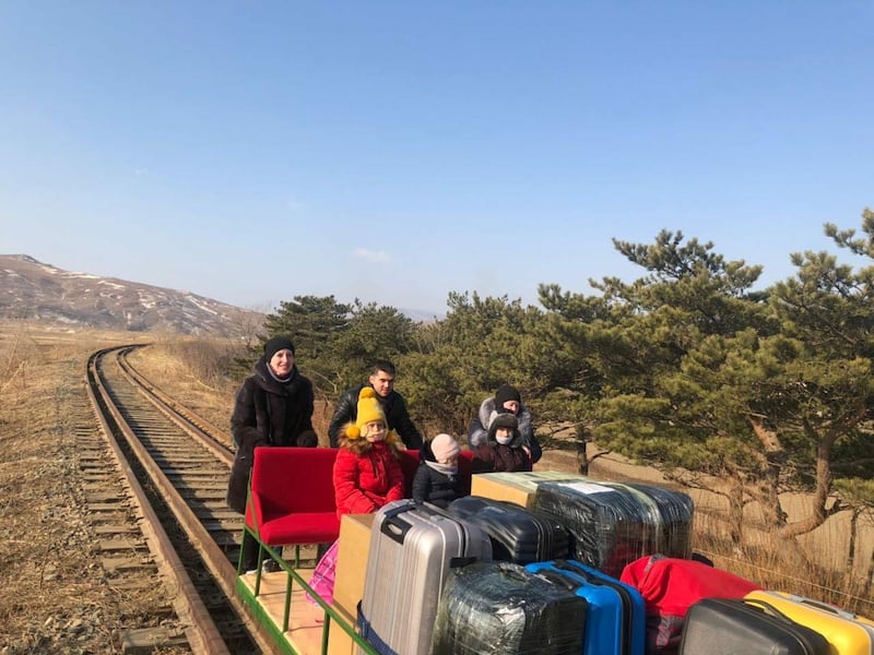 Russian diplomats and family members use a hand-pushed rail trolley to leave North Korea amid the coronavirus disease (COVID-19) restrictions while crossing the demarcation line between North Korea and Russia, February 25, 2021. Picture taken February 25, 2021. Russian Foreign Ministry/Handout via REUTERS  ATTENTION EDITORS - THIS IMAGE WAS PROVIDED BY A THIRD PARTY. NO RESALES. NO ARCHIVES. MANDATORY CREDIT.