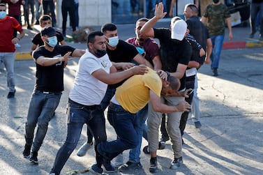 Palestinian plainclothes security officers detain a man during a demonstration in the West Bank city of Ramallah on Saturday. AFP