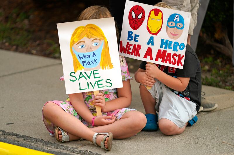 Lucie Phillips, 6, and her brother David Phillips, 3, join parents and students during a rally at Utah State School Board Office calling for mask mandate on August 6, 2021, in Salt Lake City.  AP