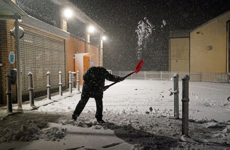 A man clears snow in Tow Law, County Durham. PA