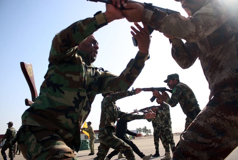 Fighters from a Popular Mobilisation unit take part in an exercise during their graduation ceremony in the southern Iraqi city of Basra, on April 9, 2015.