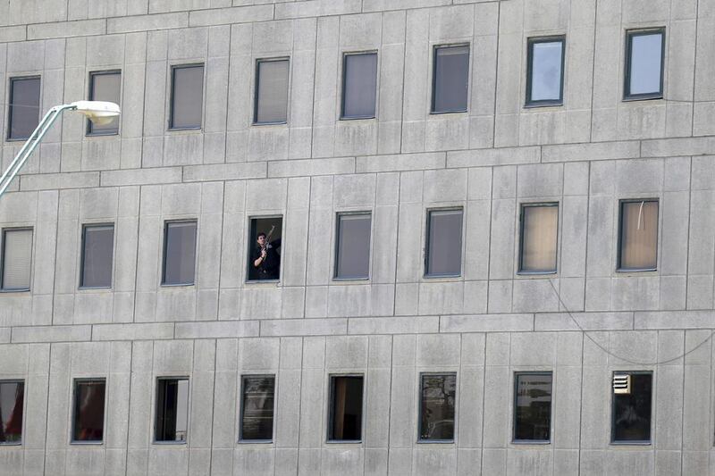 An armed man looks out of a window in Tehran’s parliament building. Omid Vahabzadeh / Fars News Agency via AP