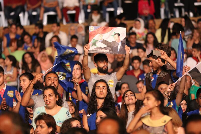 epa06925118 A man holds a poster depicting Syrian President Bashar Assad during the opening of the Bloudan Tourist Festival in Bloudan village in the countryside of Damascus, Syria, 02 August 2018 (issued 03 August 2018). The four-day festival is held under the slogan 'loyalty to the leader of the homeland and the Syrian Arab Army'. The festival includes various tourist, cultural, sportive, and film activities.  EPA/YOUSSEF BADAWI