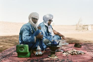 Adil (right) drinks tea with his cousin who is a nomad in Morocco's Sahara desert. Both are members of the Aarib tribe and face an uncertain future with no income while travel remains suspended due to the coronavirus.  Courtesy Una Simone Harris / Traverse Journeys