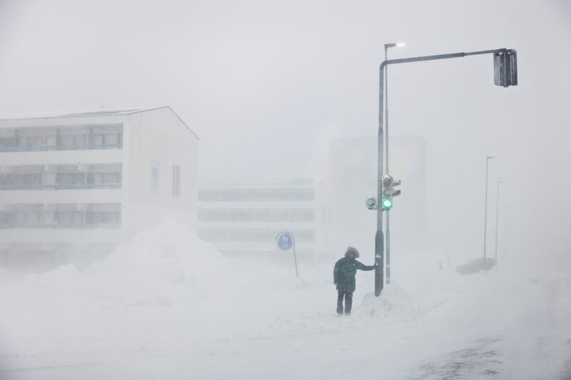 A person stands by a road during a snowstorm in Nuuk, the capital city of Greenland. Reuters
