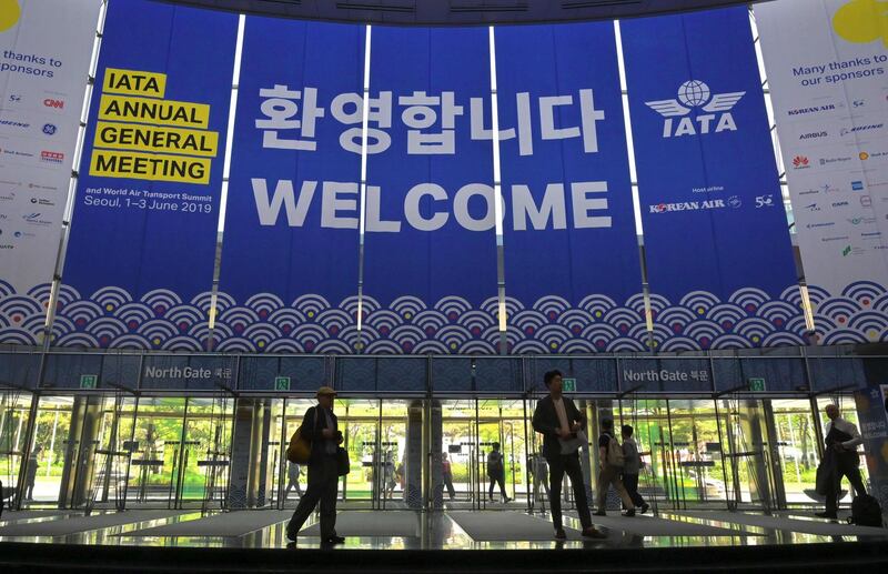 People walk past IATA banners during the annual general meeting of International Air Transport Association (IATA) at COEX convention and exhibition centre in Seoul on June 2, 2019.   AFP