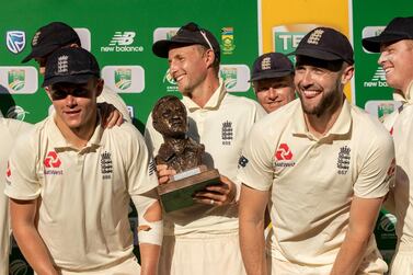 England's captain Joe Root, center, with teammates pose for photographers after receiving their trophy at the end of day four of the fourth cricket test match between South Africa and England at the Wanderers stadium in Johannesburg, South Africa, Monday, Jan. 27, 2020. England beat South Africa by 191 runs to win 3-1 series. (AP Photo/Themba Hadebe)