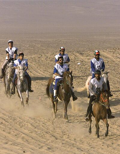 Sheikh Mohammed bin Rashid al-Maktoum (C), Crown Prince of Dubai and Defence Minister of the United Arab Emirates, moves with other compatriots in the first stages of the 100-kilometer endurance race in Saqqara, south of Cairo, 19 May 2000. Sheikh Mohammed won the first endurance horse race organized in Egypt while his sons Sheikh Rashid and Sheikh Hamdan came second and third. (ELECTRONIC IMAGE) (Photo by MARWAN NAAMANI / AFP)