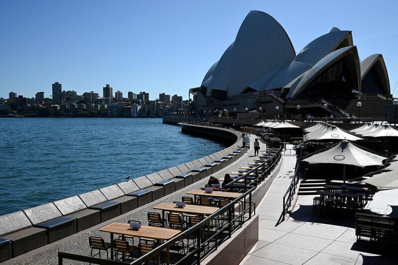 Tables at an open restaurant are seen mostly deserted on a quiet morning at the waterfront of the Sydney Opera House, where scheduled public performances have been cancelled due to the coronavirus disease (COVID-19), in Sydney, Australia, March 18, 2020.  REUTERS/Loren Elliott