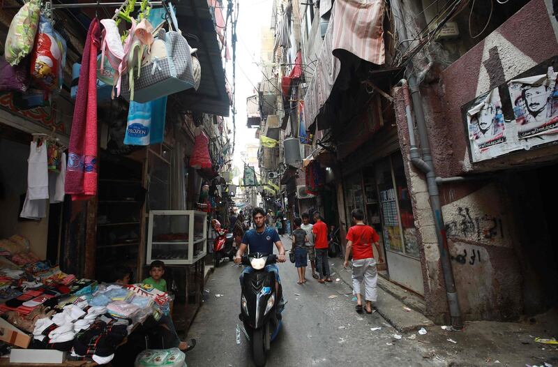 A man rides his scooter in a street in the Shatila Palestinian refugee camp, on the southern outskirts of the Lebanese capital Beirut, on September 1, 2018. - Palestinians reacted angrily today to a US decision to end all funding for the UN agency that assists millions of refugees, seeing it as a new policy shift aimed at undermining their cause. (Photo by ANWAR AMRO / AFP)