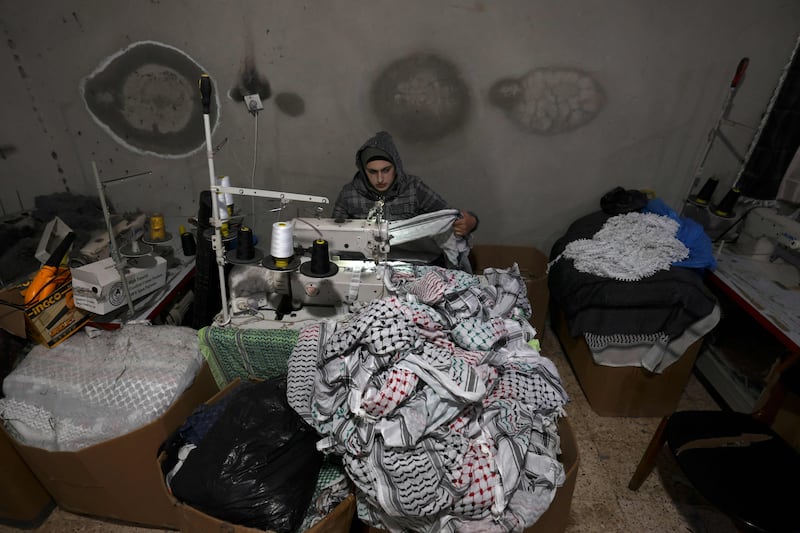 A worker sewing at the Hirbawi keffiyeh in Hebron. AFP