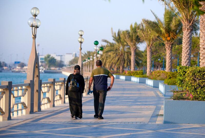 Abu Dhabi, United Arab Emirates, June 28, 2020.   
  A couple walks along the Corniche pathway as the sun sets on the Dhow Harbour.
Victor Besa  / The National
Section:  Standalone
Reporter:  none
