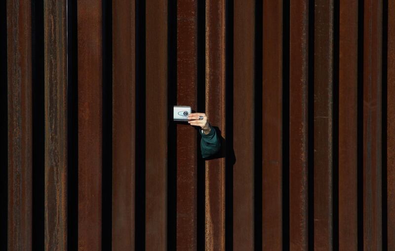 A woman in the United States takes a picture of Mexico through the border fence on the outskirts of Ciudad Juarez in Mexico. AFP