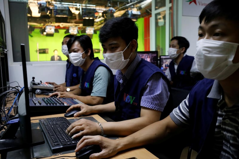 TV crew wear protective masks as they produce a programme about the coronavirus pandemic in Hanoi, Vietnam. Reuters