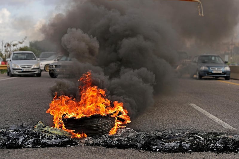 Tyres burn at a make-shift roadblock made by anti-government demonstrators in the city of Byblos, north of Lebanon's capital. AFP
