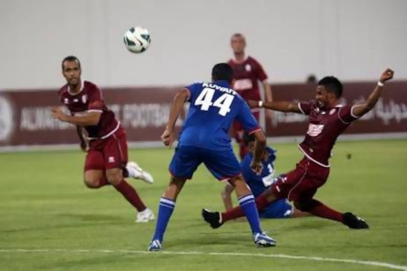 Al Wahda's Mahmoud Khamis (26) takes a shot on goal as Kuwait's Fahd Abdulaziz (44) looks on during a friendly football match on July 27.