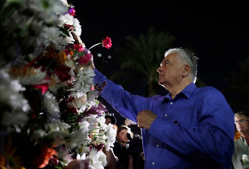 Clark County Commissioner and Nevada Democratic Gubernatorial candidate Steve Sisolak places a rose on a wall during the dedication of a healing garden. EPA