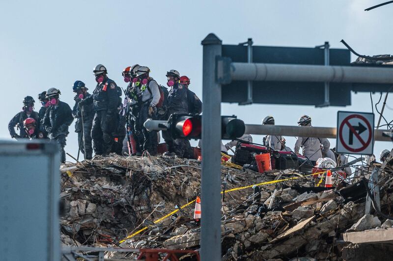 Search and Rescue teams look for possible survivors in the partially collapsed 12-story Champlain Towers South condo building on June 28, 2021 in Surfside, Florida. The death toll after the collapse of a Florida apartment tower rose to nine, officials said on June 27, 2021, with more than 150 people still missing and their weary families waiting nearly four days for information as to their fate.The outlook grew increasingly grim by the hour, however, as the slow rescue operation, involving workers sorting nonstop through the rubble in torrid heat and high humidity, carried on.
 / AFP / Giorgio VIERA
