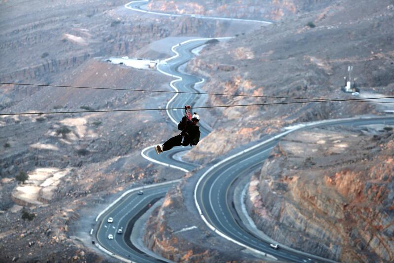 A picture taken on February 3, 2018, shows a woman riding the world's longest zip line, which measures almost 3 km in length, in Ras Al Khaimah in the United Arab Emirates. (Photo by KARIM SAHIB / AFP)