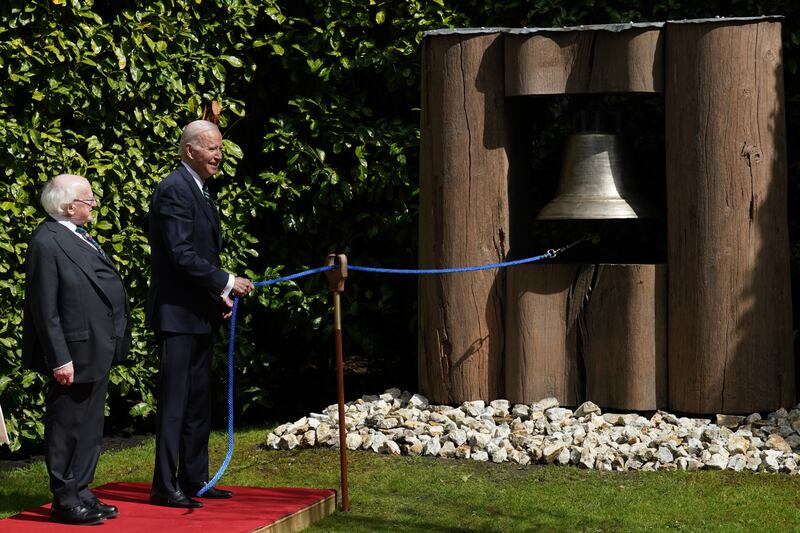 Irish President Michael Higgins watches as Mr Biden rings the Peace Bell. PA