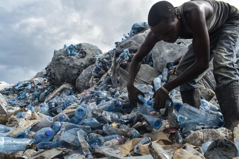 A man sorting out plastic PET bottles at the Kibarani dump site in Mombasa, Kenya. Andrew Kasuku / AFP
