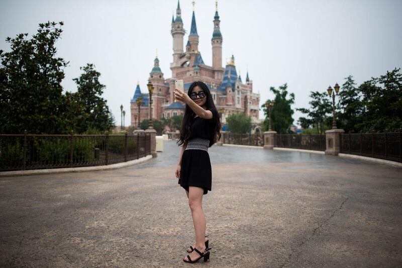 A woman takes a selfie in front of the Enchanted Storybook Castle at Shanghai Disney Resort in Shanghai. Disney opens its first theme park in mainland China on Thursday. Johannes Eisele/AFP