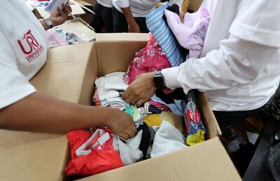 ABU DHABI, UNITED ARAB EMIRATES, August 19 – 2018 : Members of the Universal Rescue Team packing essential items such as slippers, clothes , food , medicines , blankets, baby items and other stuff in the aid boxes for the Kerala flood victims at the Universal Hospital in Abu Dhabi. ( Pawan Singh / The National )  For News. Story by John Dennehy