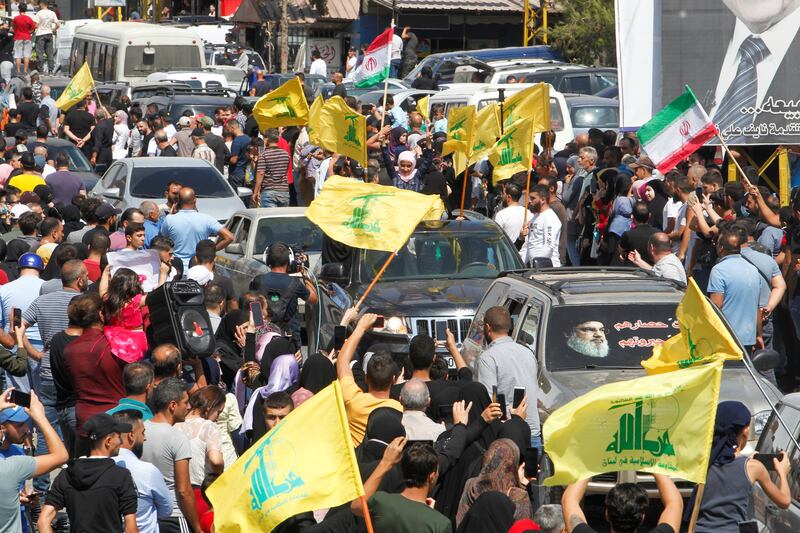 Hezbollah supporters cheer and fire guns into the air. Reuters