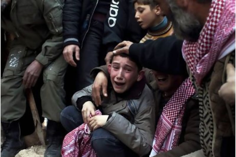 A young boy, Ahmed, is comforted by mourners during the funeral in Idlib of his father, who was killed by a Syrian army sniper. Rodrigo Abd