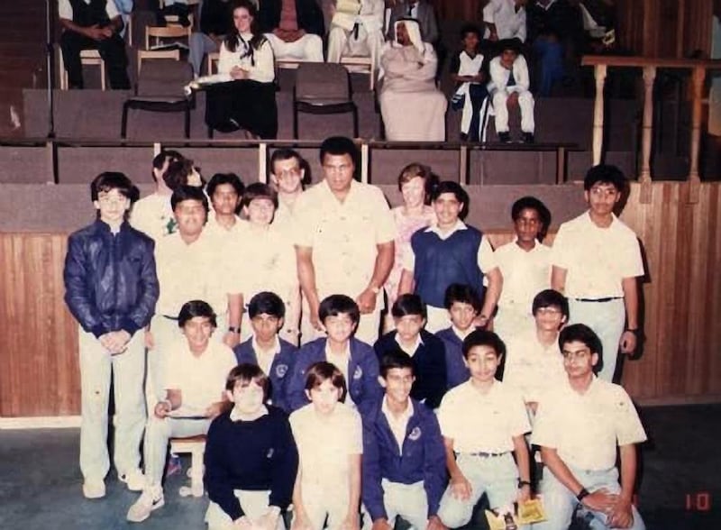 Muhammad Ali at Al Nahda School in Abu Dhabi. Ahmed sits in the front row wearing a blue jacket. The class teacher, Mr Davis, wears glasses and stands behind Ali. Shane is stood in line with Ali, second from the left, and wears a blue jacket. Ahmed stands next to Shane. Wael is second from the right, in line with Ali. Courtesy Awad Mustafa