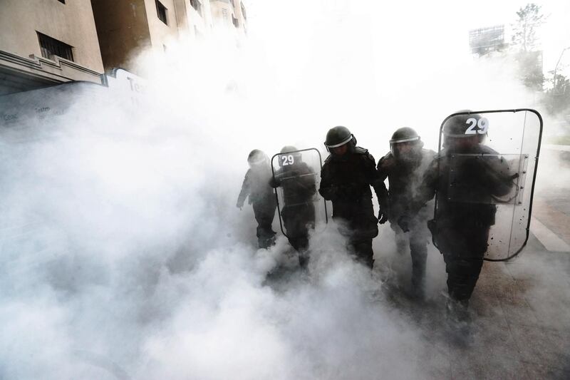 Members of the Carabineros Special Forces walk within a cloud of tear gas during a rally in Santiago, Chile. The rally was held to demand justice a month after the death of the Mapuche community member, Camilo Catrillanca, during a police operation in the south of the country. EPA