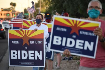 Members of the group "Arizona Republicans Who Believe In Treating Others With Respect" hold signs in support of Democratic presidential candidate Joe Biden, during evening rush hour in Phoenix, Arizona on October 16, 2020. Arizona has not elected a Democrat since Bill Clinton's second win in 1996, but is undergoing major demographic changes. The state best known abroad for the Grand Canyon is seeing a rapid growth in urban areas, among young college-educated voters, and in its robust Latino community -- groups that tend to favor the Democratic Party. But key to next month's election is that the average Arizona voter, whether Republican or Democrat, tends to be more moderate and is "tired of the President's behavior and the rhetoric coming from his campaign," according to Arizona State University politics lecturer Gina Woodall. / AFP / Robyn Beck
