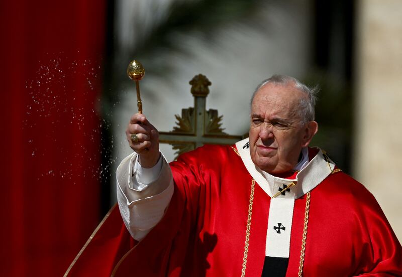 Pope Francis blesses the olive branches as he leads the Palm Sunday mass in St Peter's Square. AFP