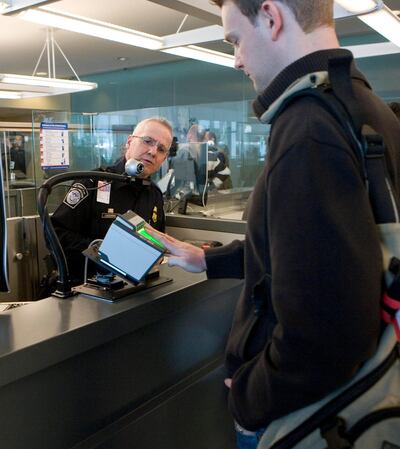 A Homeland Security officer instructs a traveller as he is fingerprinted using a biometric scanner at the JFK International Airport in New York, U.S., on Tuesday, March 25, 2008.
Ramin Talaie (Newscom TagID: raminphotos000665)     [Photo via Newscom]