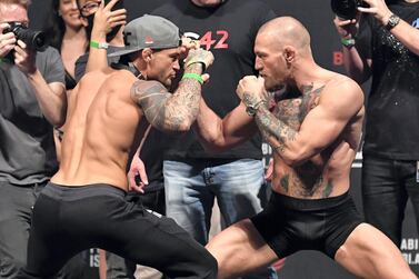 Dustin Poirier and Conor McGregor face off during the UFC 257 weigh-in at Etihad Arena on UFC Fight Island in Abu Dhabi. Jeff Bottari/Zuffa LLC)